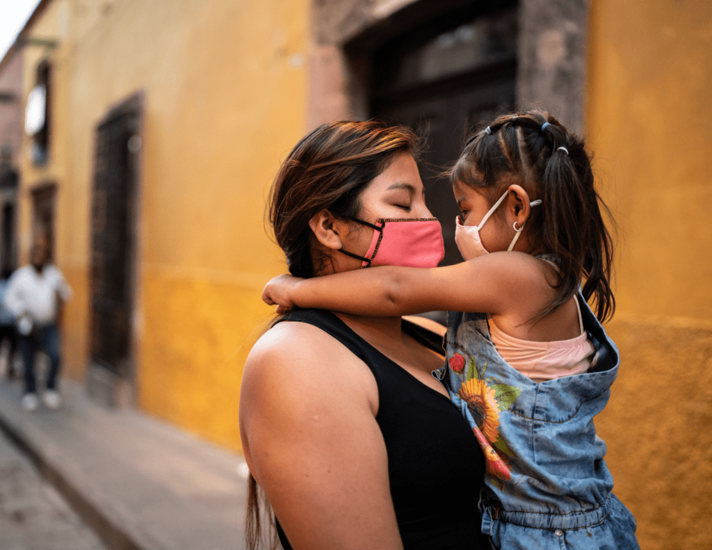Woman with child in masks in Latin America